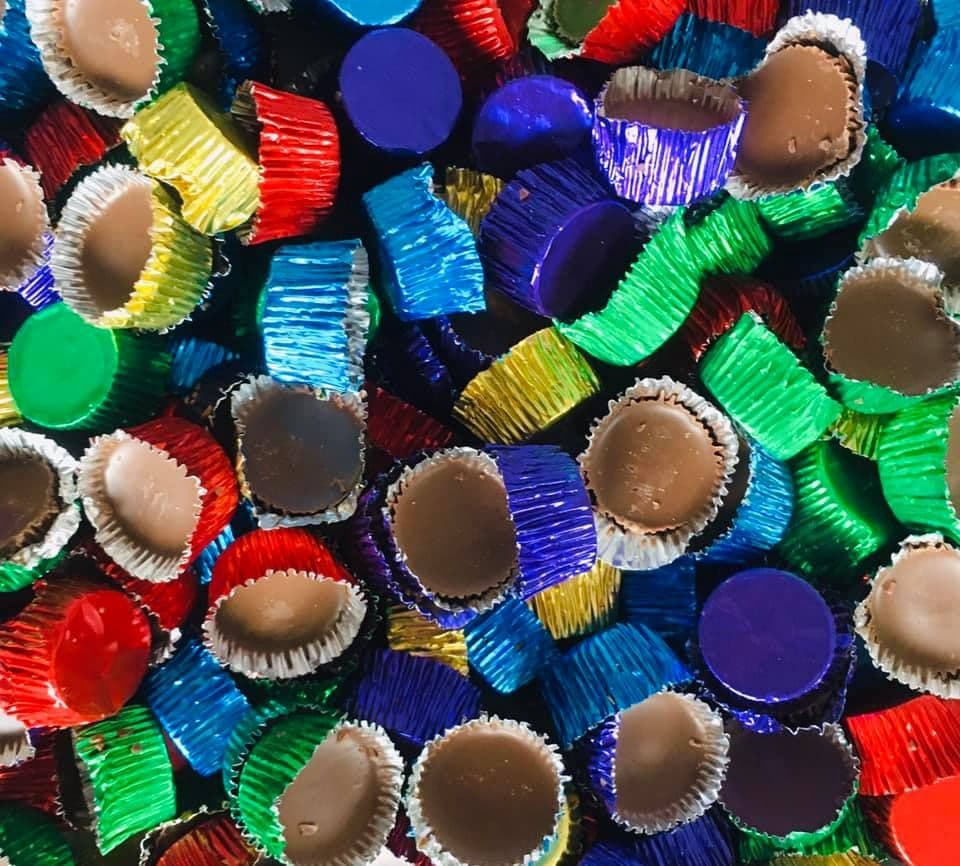 A collection of colorful candy cups with chocolate coating, assorted in various shapes and colors.