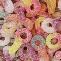 A close-up view of colorful sour dummies candies with a sugary coating, displaying various colors.